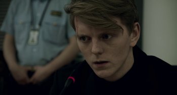 Movie still from “22 July” (2018), directed by Paul Greengrass – A young man with long blonde hair wearing a black shirt; Close Up shot, Over the shoulder angle