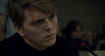 Movie still from “22 July” (2018), directed by Paul Greengrass – A young man with a scar on his face; Close Up shot, Over the shoulder angle