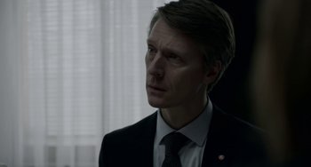Movie still from “22 July” (2018), directed by Paul Greengrass – A person wearing a suit and tie; Close Up shot, Over the shoulder angle
