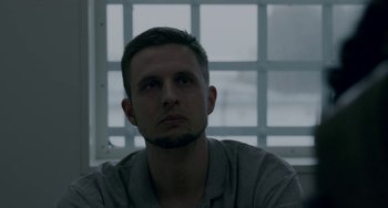 Movie still from “22 July” (2018), directed by Paul Greengrass – A person sitting in front of a window; Close Up shot, Low angle