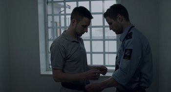 Movie still from “22 July” (2018), directed by Paul Greengrass – Two men standing next to each other in front of a window; Medium shot, Over the shoulder angle