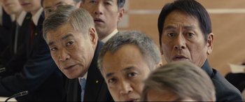 Movie still from “Shin Godzilla” (2016), directed by Shinji Higuchi – A group of men standing next to each other in a room; Close Up shot, Low angle
