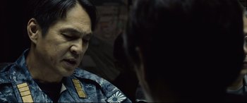 Movie still from “Shin Godzilla” (2016), directed by Shinji Higuchi – A man in a uniform talking to another man in a uniform; Close Up shot, Over the shoulder angle
