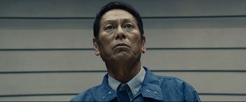 Movie still from “Shin Godzilla” (2016), directed by Shinji Higuchi – An older man wearing a blue jacket looking up; Close Up shot, Low angle