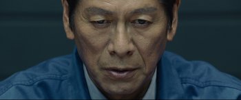 Movie still from “Shin Godzilla” (2016), directed by Shinji Higuchi – A man's face in a blue shirt; Extreme Close Up shot, Low angle