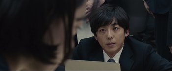 Movie still from “Shin Godzilla” (2016), directed by Shinji Higuchi – A man in a business suit looking at his reflection in a mirror; Close Up shot, Over the shoulder angle