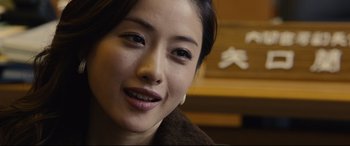 Movie still from “Shin Godzilla” (2016), directed by Shinji Higuchi – A woman's face in a brown jacket; Close Up shot, Over the shoulder angle