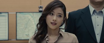 Movie still from “Shin Godzilla” (2016), directed by Shinji Higuchi – A beautiful young woman with long dark brown hair; Close Up shot, Over the shoulder angle