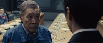 Movie still from “Shin Godzilla” (2016), directed by Shinji Higuchi – A man and a woman sitting in front of each other; Close Up shot, Over the shoulder angle