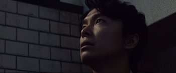 Movie still from “Shin Godzilla” (2016), directed by Shinji Higuchi – A person looking up at the sky; Close Up shot, Low angle