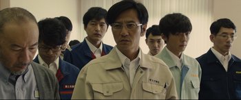 Movie still from “Shin Godzilla” (2016), directed by Shinji Higuchi – A group of men standing in a room; Medium shot, Low angle