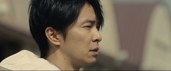 Movie still from “Shin Godzilla” (2016), directed by Shinji Higuchi – A person with short black hair; Close Up shot, Low angle