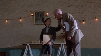 Movie still from “Shine” (1996), directed by Scott Hicks – A man and a boy are standing next to each other; Medium shot, Low angle