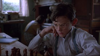 Movie still from “Shine” (1996), directed by Scott Hicks – A young boy sitting in front of a chessboard; Close Up shot, Low angle