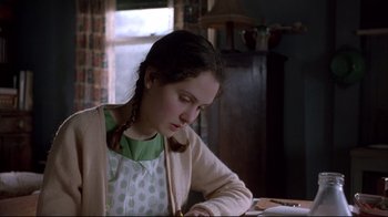 Movie still from “Shine” (1996), directed by Scott Hicks – A young girl sitting at a table writing on a piece of paper; Close Up shot, Over the shoulder angle