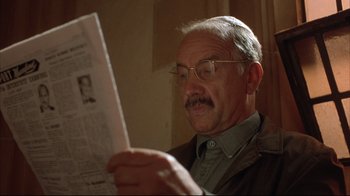 Movie still from “Shine” (1996), directed by Scott Hicks – An older man reading a newspaper in a room; Close Up shot, Low angle