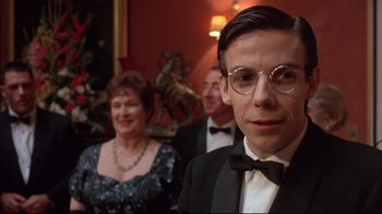 Movie still from “Shine” (1996), directed by Scott Hicks – A man in a suit and tie standing in front of a woman; Close Up shot, Low angle