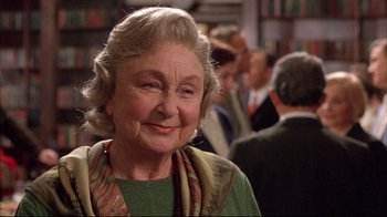 Movie still from “Shine” (1996), directed by Scott Hicks – An older woman smiling at the camera in front of a group of people; Close Up shot, Over the shoulder angle