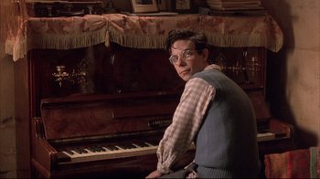 Movie still from “Shine” (1996), directed by Scott Hicks – A man sitting in front of an old piano; Medium shot, High angle