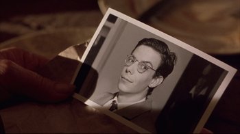 Movie still from “Shine” (1996), directed by Scott Hicks – An old photo of a man wearing glasses; Close Up shot, High angle