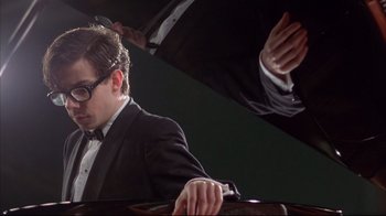 Movie still from “Shine” (1996), directed by Scott Hicks – A man in a tuxedo is playing a piano; Close Up shot, Low angle