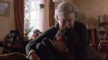 Movie still from “Shine” (1996), directed by Scott Hicks – An older woman is holding a small dog; Medium shot, Over the shoulder angle