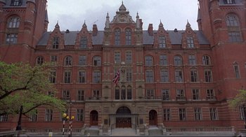 Movie still from “Shine” (1996), directed by Scott Hicks – A large brick building with a flag on the front of it; Extreme Wide shot, Low angle