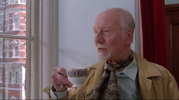 Movie still from “Shine” (1996), directed by Scott Hicks – An older man holding a coffee cup while wearing a neck tie; Close Up shot, Low angle