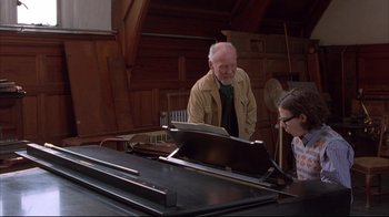 Movie still from “Shine” (1996), directed by Scott Hicks – An older man and a young girl are playing a piano; Medium shot, Over the shoulder angle