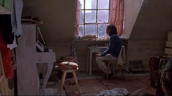 Movie still from “Shine” (1996), directed by Scott Hicks – A woman sitting at a desk in front of a window; Wide shot, High angle
