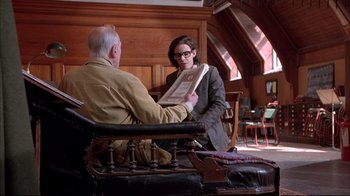 Movie still from “Shine” (1996), directed by Scott Hicks – A man and a woman sitting at a table holding papers; Medium shot, Over the shoulder angle