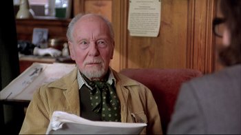 Movie still from “Shine” (1996), directed by Scott Hicks – An older man sitting in a chair in front of a wooden wall; Close Up shot, Over the shoulder angle