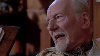 Movie still from “Shine” (1996), directed by Scott Hicks – An old man with a beard and mustache is looking at the camera; Close Up shot, Over the shoulder angle