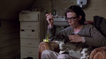 Movie still from “Shine” (1996), directed by Scott Hicks – A person sitting on a chair with a cat; Medium shot, Low angle