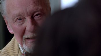 Movie still from “Shine” (1996), directed by Scott Hicks – An old man with a beard and mustache looking at the camera; Close Up shot, Over the shoulder angle