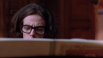 Movie still from “Shine” (1996), directed by Scott Hicks – A man with glasses is reading a book; Close Up shot, Low angle