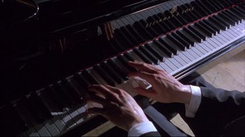 Movie still from “Shine” (1996), directed by Scott Hicks – A person playing a piano with their hands on the keys; Extreme Close Up shot, Overhead angle