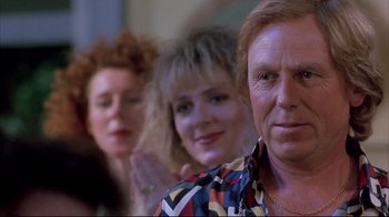 Movie still from “Shine” (1996), directed by Scott Hicks – A man and two women standing next to each other in a room; Close Up shot, Over the shoulder angle