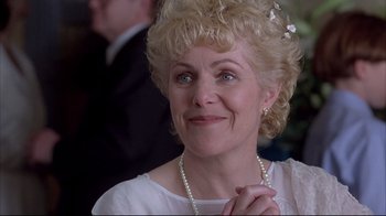 Movie still from “Shine” (1996), directed by Scott Hicks – An older woman wearing a white dress and pearl necklace; Close Up shot, Over the shoulder angle