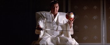 Movie still from “Shogun Assassin” (1980), directed by Kenji Misumi – A man dressed in a white robe holding a sword and a ball; Medium shot, Low angle