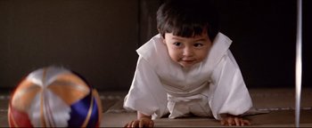 Movie still from “Shogun Assassin” (1980), directed by Kenji Misumi – A little boy in a white kimono is laying on the floor; Close Up shot, Low angle