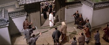 Movie still from “Shogun Assassin” (1980), directed by Kenji Misumi – A group of people are holding swords in a courtyard; Wide shot, High angle