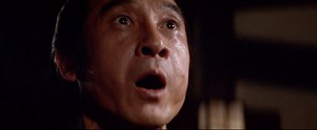 Movie still from “Shogun Assassin” (1980), directed by Kenji Misumi – An asian man with an open mouth looking up; Extreme Close Up shot, Low angle