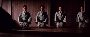 Movie still from “Shogun Assassin” (1980), directed by Kenji Misumi – A woman in a kimono sitting on the ground in front of a mirror; Wide shot, Low angle
