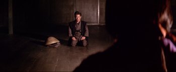 Movie still from “Shogun Assassin” (1980), directed by Kenji Misumi – A man sitting on the ground in a room; Wide shot, High angle