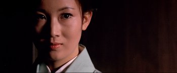 Movie still from “Shogun Assassin” (1980), directed by Kenji Misumi – A woman's face in a white shirt; Close Up shot, Low angle