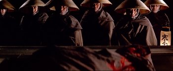 Movie still from “Shogun Assassin” (1980), directed by Kenji Misumi – A group of people wearing asian hats and robes; Medium shot, High angle