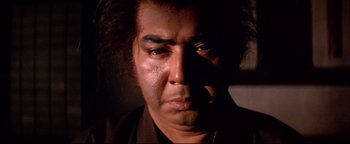 Movie still from “Shogun Assassin” (1980), directed by Kenji Misumi – A man's face in the dark; Close Up shot, Low angle