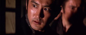 Movie still from “Shogun Assassin” (1980), directed by Kenji Misumi – A man's face in the dark; Close Up shot, Low angle