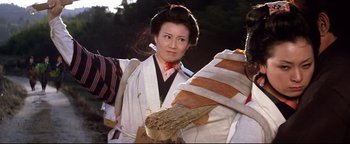 Movie still from “Shogun Assassin” (1980), directed by Kenji Misumi – A woman in traditional japanese clothing holding a basket; Close Up shot, Low angle